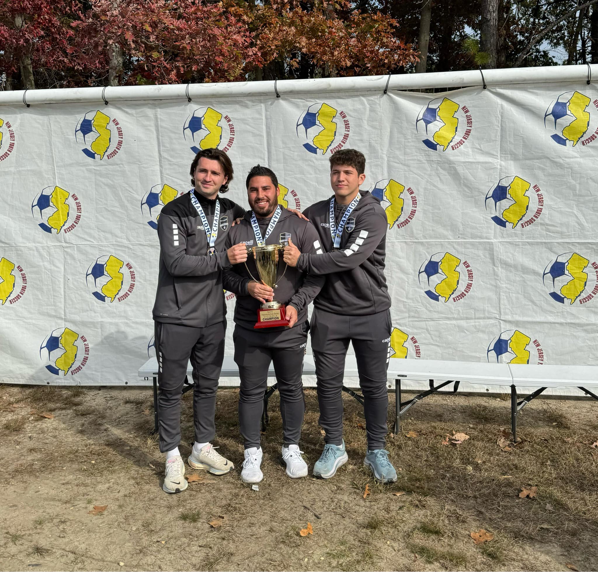 Deptford Soccer Association coaching staff celebrating a State Cup championship